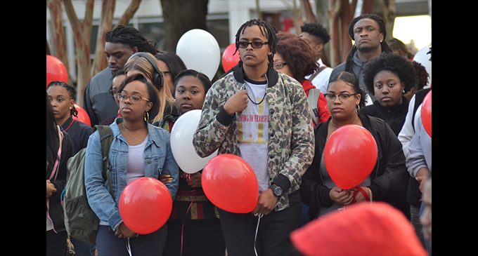 Vigil honors student as police look for suspect