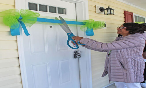 New homeowner cuts ribbon and opens door to her new home