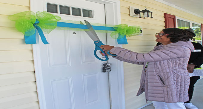 New homeowner cuts ribbon and opens door to her new home